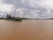 Panoramic view of brown murky waters of Mekong Delta with old cargo ship under cloudy sky. Nature and navigable rivers. Asian