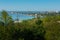 Panoramic view of bustling harbor with cranes. Ships docked at industrial sea port. Urban skyline against clear blue sky