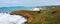 Panoramic view of California rugged Pacific ocean coastline with green hills near Pacifica during overcast winter day