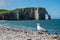 Panoramic view on chalk cliffs and Porte d`Aval arch in Etretat, Normandy, France. Tourists destination