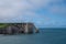 Panoramic view on chalk cliffs and Porte d`Aval arch in Etretat, Normandy, France. Tourists destination