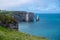 Panoramic view on chalk cliffs and Porte d`Aval arch in Etretat, Normandy, France. Tourists destination