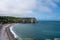 Panoramic view on chalk cliffs and Porte d`Aval arch in Etretat, Normandy, France. Tourists destination