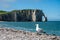 Panoramic view on chalk cliffs and Porte d`Aval arch in Etretat, Normandy, France. Tourists destination