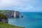 Panoramic view on chalk cliffs and Porte d`Aval arch in Etretat, Normandy, France. Tourists destination