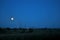 A panoramic view of the chimneys and cooling towers of the CHP plant against the background of the night sky and the full moon