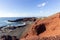 Panoramic view on the coastline of El Golfo with red and black colored volcanic rock formations and lava fields on canary island