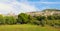 Panoramic view from countryside of the historic town of Assisi in beautiful sunny day with blue sky and clouds in summer, Umbria,