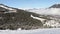 Panoramic view down a mountain valley range with ski resort village