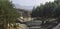 Panoramic view of a dry riverbed running through pine forests, rocks