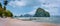 Panoramic view of El Nido coastline with traditional filippino boats on beach and Pinagbuyutan island in background