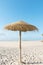 Panoramic view of empty broad beach with white sand blue sea sky straw umbrella volleyball net. Sunny summer day