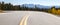 Panoramic view of an empty road winding through a mountain landscape in Colorado
