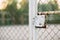 Panoramic view of the fence grid with a lock with a sports field behind