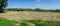 Panoramic view of field of mown hay in beautiful setting