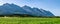 Panoramic view at five of Seven Sisters Mountain range on Sandnessjoen, ideally green grass, small Norwegian village and mountains