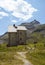 Panoramic view of a former alpine shelter with mountain peak in background