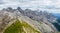 Panoramic view of a girl climber standing on the top of cliff in Dolomites Mountains. Italian Dolomites. Panoramic view of girl wa