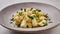 Panoramic view gnocchi, prepared with potato and whole grain flour dough with cream sauce and parsley on gray ceramic