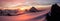 Panoramic view of gorgeous pink sunrise over glacier and high mountain peaks in the Alps