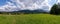 Panoramic view of green grass meadow countryside field with A shaped houses against sleeping knight tatra mountain aka as giewont