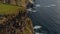 Panoramic view of high cliffs on rugged sea coast. Ascending shot and tilt down on lookout point on edge of rock. Cliffs