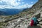 Panoramic view from Hohe Sonnblick in Austrian Alps on Grossglockner.  A woman with hiking backpack resting