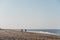 Panoramic view of Horsey Gap beach in spring, silhouettes of people walking by the water on the background., Norfolk, UK