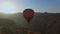 Panoramic view of hot air balloon flying across the sky in mountain landscape