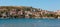 Panoramic view of houses near coastal people swimming sunbathing on the rocks in the boats