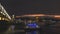 Panoramic view of Istanbul cityscape with Suleymaniye mosque with tourist ships floating at Bosphorus at night.
