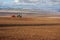 panoramic view of land, tractor with seeder, sowing time in spring