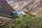 Panoramic view at landscape between Betancuria and Pajara  on Fuerteventura with dammed lake and multi colored volcanic mountais