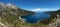 Panoramic View of Large Bay and Lake with Boats, Small Island, Trees and Mountains.