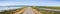 Panoramic view of levee going through the marsh and ponds in south San Francisco bay, California