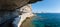 Panoramic view looking out from a coastal path cut into the side of a white limestone chalk cliff which leads to the King of Arago