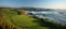 Panoramic view of lush golf course on white cliffs with iconic rock arches by the stunning blue sea