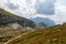 Panoramic view on Mangart Road, Mangartska cesta, with parking Cars and Mountain Chain. Look from Mangart Saddle, Mangartsko sedlo