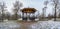 Panoramic view of metal openwork gazebo in public park in winter