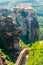 Panoramic view from Meteoron Monastery cliff stone stairs with metal railings on scenic Meteora landscape rock formations with