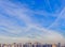 Panoramic view of Modern city with houses and cranes, clouds and blue sky.