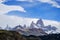 a panoramic view of The mount Fitz Roy over the blue sky with some clouds