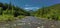 Panoramic view of the mountain river with green forest, blue sky with white clouds. Carpathians, Ukraine