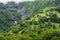 Panoramic view on mountain waterfalls, green forests and apline meadows near Saint-Gervais-les-Bains, Savoy. France
