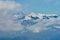 Panoramic view of the mountains. In the foreground clouds, in the middle snow-covered winter forest. Lago-Naki, The Main Caucasian