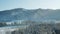 Panoramic view of the mountains. Snow-covered trees at the foot of the mountain. Sunrise in the mountains, coniferous