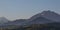 Panoramic view of the mountains of the Trans-Ili Alatau, rising above the houses during the summer sunrise.