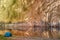 Panoramic view of narrow mountain lake or river with high sheer cliffs in soft light of setting sun on background and blue tourist