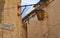 Panoramic view on a old, antic, medieval and historic lantern hanging on a sand stone wall. In the Background the castle of Mdina