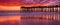 Panoramic view of an old pier on the ocean at sunset